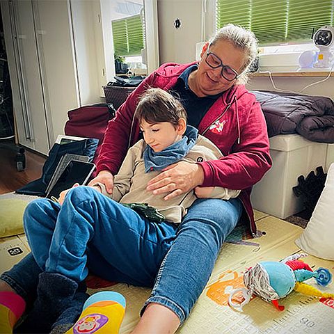 eine Pflegerin mit einem pflegebed�rftigem Kind im Spielbereich