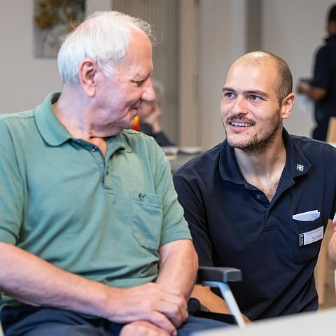 Eine Pflegekraft spricht mit einem Bewohner
